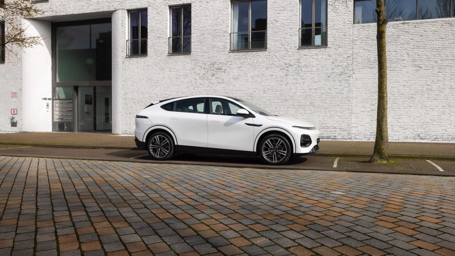 une voiture blanche garée devant un bâtiment