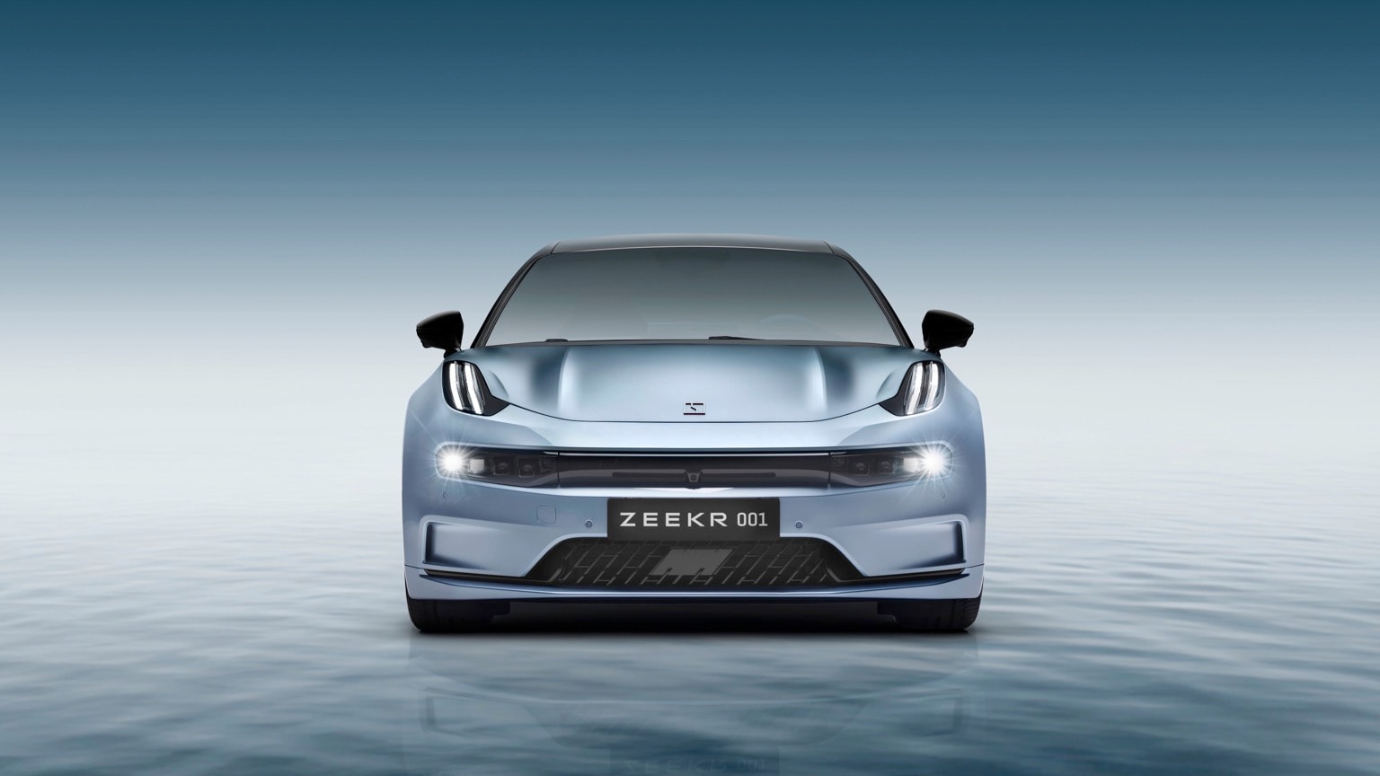 a blue sports car with its headlights on